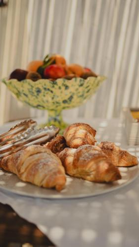 a plate of pastries and a bowl of fruit on a table at Casa Mita in Pulsano