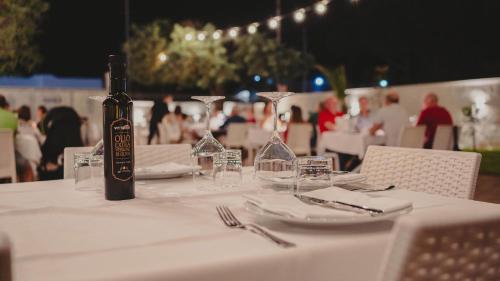 a bottle of wine sitting on a table with glasses at Casa Mita in Pulsano