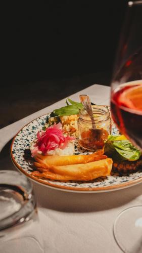 a plate of food on a table with a glass of wine at Casa Mita in Pulsano
