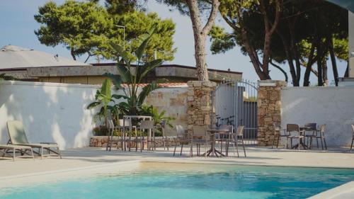 a pool with chairs and tables next to a fence at Casa Mita in Pulsano