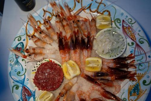 a plate of shrimp with lemon slices and sauce at Casa Mita in Pulsano