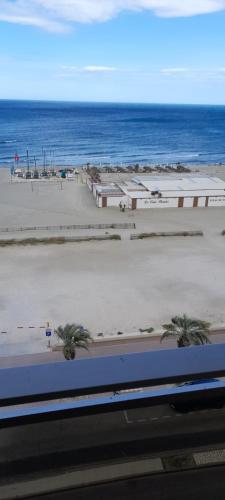 - une vue sur la plage et l'océan en arrière-plan dans l'établissement Grand appartement standing front de mer 90 m2, à Canet