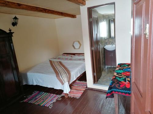 um pequeno quarto com uma cama e um espelho em La cascada Sipot em Merişor