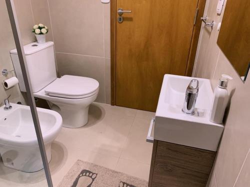 ein weißes Bad mit einem WC und einem Waschbecken in der Unterkunft Alquiler Temporario SG in Lincoln