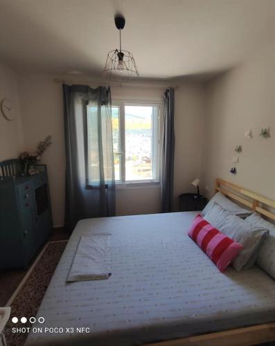 a bedroom with a large bed with a red pillow on it at Neoclassical Samos House Nafsika in Samos