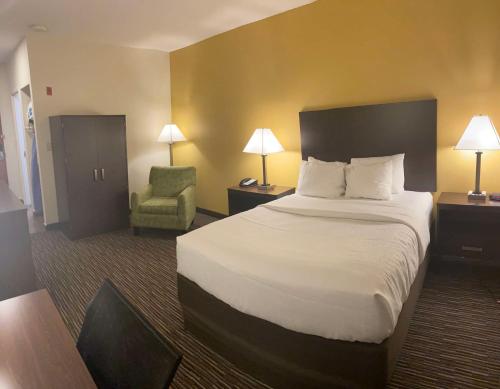 a hotel room with a bed and a chair at SureStay by Best Western Grayson in Grayson