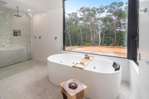 a white bath tub in a bathroom with a window at Raffaele's Estate - Margaret River in Wilyabrup