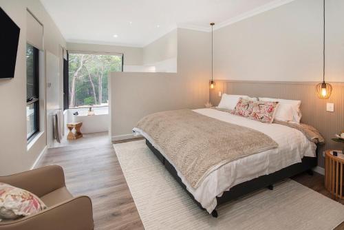 a bedroom with a large bed and a chair at Raffaele's Estate - Margaret River in Wilyabrup
