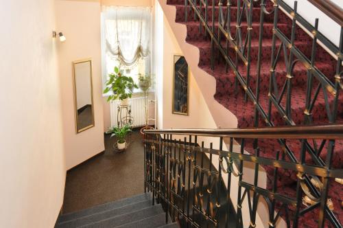 a staircase in a house with a red rug at Hotel Wilhelm in Prague