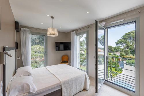 1 dormitorio con 1 cama y balcón en Luxueuse Villa Charleston - Vue mer, Sauna Hammam, en Antibes