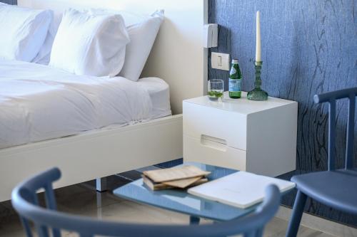 a bedroom with a bed with a table and two chairs at HaTsuk Beach Sea-View Studio by Sea N' Rent in Jlil