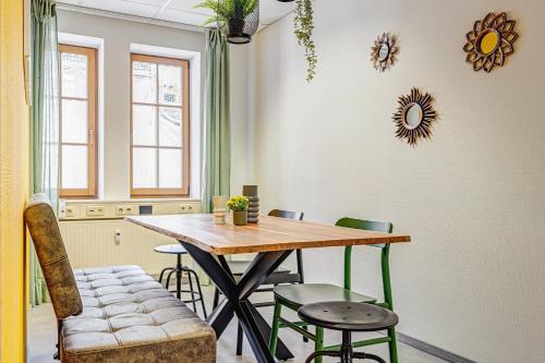 a dining room with a wooden table and chairs at Pressehaus Apartment Obermarkt One in Mühlhausen