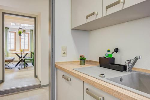 ミュールハウゼンにあるPressehaus Apartment Obermarkt Oneのキッチン(シンク、テーブル付)