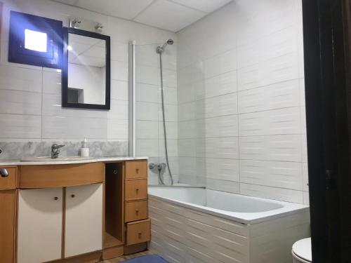 a white bathroom with a tub and a sink at Apartamento Begur (costa brava) in Begur