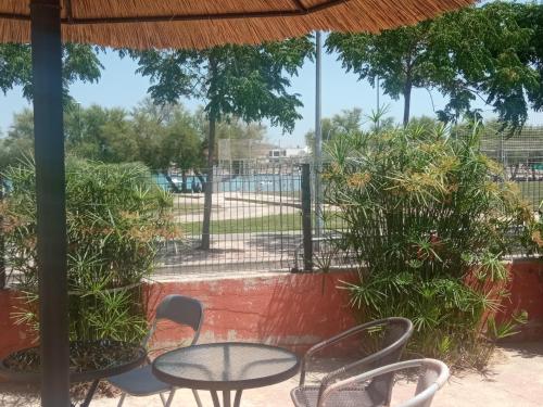 une terrasse avec une table, des chaises et des arbres dans l'établissement Basil Apartments and Rooms, à Betina