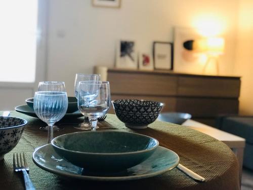 - une table avec des assiettes et des verres à vin dans l'établissement Mone - La Maison Racine 1 - Duplex avec terrasse, à Avignon