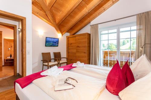 a bedroom with a large bed with red pillows at Appartements Ferienwohnungen Unser Unterberg in Maria Alm am Steinernen Meer