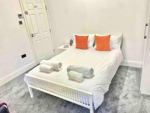 a large white bed with orange and white pillows on it at Apartment in ideal location in Sheffield in Nether Edge