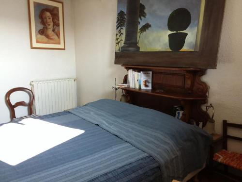 um quarto com uma cama com um cobertor azul em Charme centre historique 17e siècle em Aramon