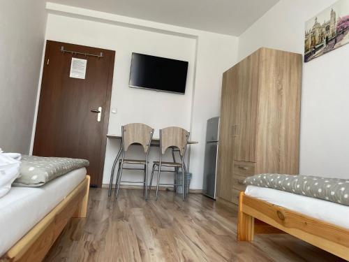 a room with two beds and a table and chairs at Różana 51 in Opole