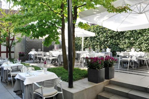 a restaurant with white tables and chairs and umbrellas at Widder Hotel - Zurichs luxury hideaway in Zurich