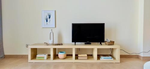 a television sitting on top of a wooden stand at APARTAMENTO DO LAGAR in Algoz