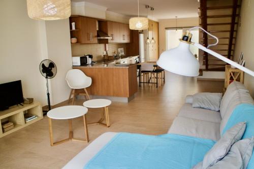 a living room with a couch and a kitchen at APARTAMENTO DO LAGAR in Algoz