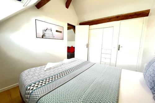 - une chambre avec un lit et une photo sur le mur dans l'établissement M12 - Le vieux MassyRER600mOrly20 minNetflixNeuf, à Massy