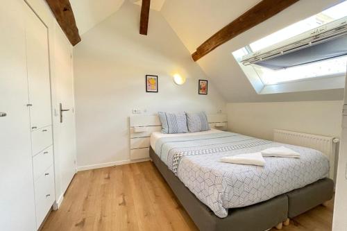 une chambre avec un lit et une lucarne dans l'établissement M12 - Le vieux MassyRER600mOrly20 minNetflixNeuf, à Massy