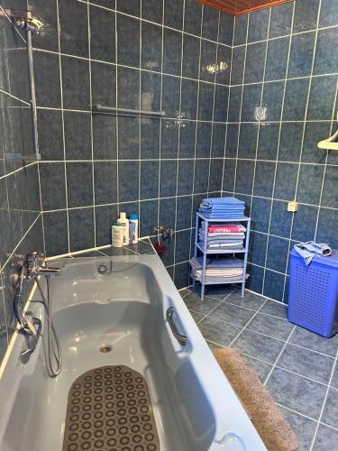 a bath tub in a bathroom with blue tiles at Guesthouse Centro in Mostar