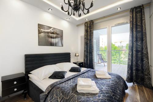 sypialnia z dużym łóżkiem i dwoma ręcznikami na nim w obiekcie About Art Apartments - Sikorskiego we Wrocławiu