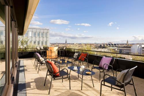 d'une terrasse avec des chaises et des tables sur un balcon. dans l'établissement FirstName Bordeaux by Hyatt, à Bordeaux