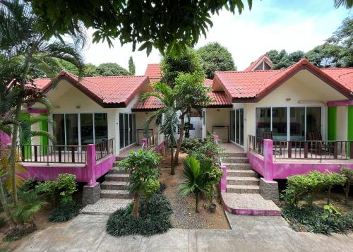 ラマイにあるMae Somboon Houseのピンクと緑の絵付けの家