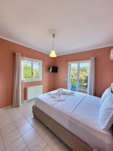 a bedroom with a large bed and two windows at The View Point Apartment 1 in Tsoukalades