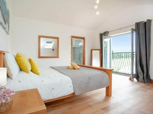 a bedroom with a bed and a large window at Cosy cottage in the Blackdown hills Devon in Honiton
