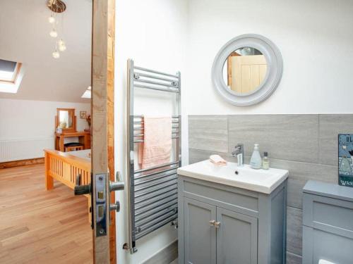 ein Bad mit einem Waschbecken und einer Dusche mit einem Spiegel in der Unterkunft Cosy cottage in the Blackdown hills Devon in Honiton