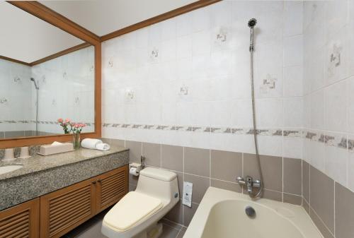 a bathroom with a toilet and a sink and a tub at Riverine Place Hotel and Residence in Nonthaburi