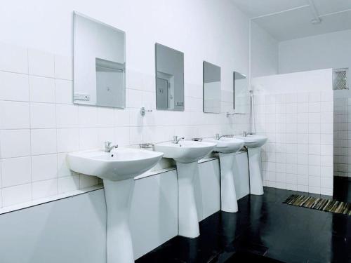 a row of sinks in a bathroom with mirrors at Havelock City Hostel, Colombo in Colombo