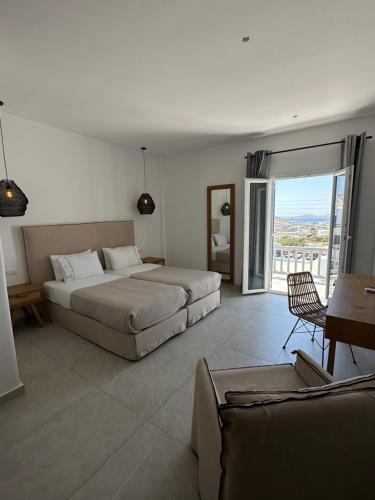 a bedroom with two beds and a balcony at Anna-Maria Mykonos Hotel in Glastros