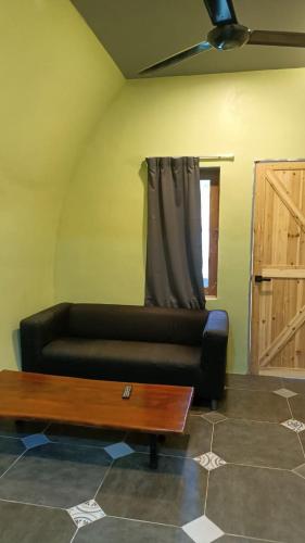 a living room with a couch and a coffee table at Villa Motel Mas Guesthouse in Batang Berjuntai