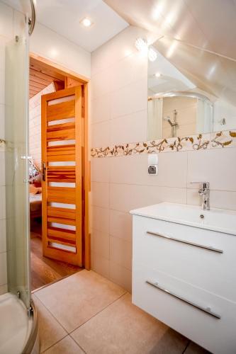 a bathroom with a sink and a mirror at Willa Góralska in Biały Dunajec