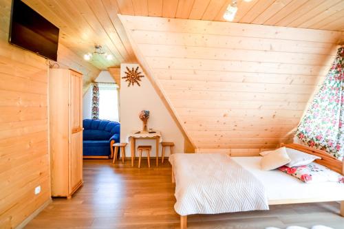 Habitación en una cabaña de madera con cama y mesa en Willa Góralska en Biały Dunajec