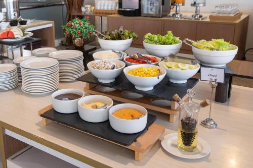 a buffet with bowls of food on a table at Riverine Place Hotel and Residence in Nonthaburi
