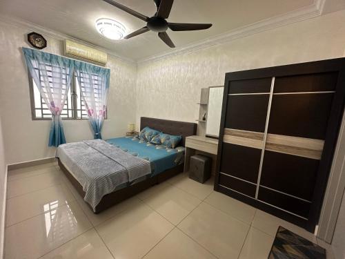 Schlafzimmer mit einem Bett und einem Deckenventilator in der Unterkunft Aqilla Homestay in Kuala Selangor