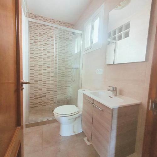 a white bathroom with a toilet and a sink at Luminosa casa en Nerja in Nerja