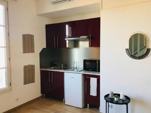 une cuisine avec des placards violets et un four micro-ondes dans l'établissement Marie - La Maison Racine 2 - Joli duplex sous les toits, à Avignon