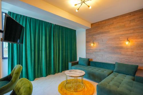 un soggiorno con divano verde e TV di Green Luxury Apartament a Mamaia Nord - Năvodari