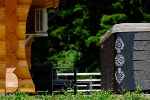 a black chair sitting next to a building at Kompleks Gazdówka Domki Rabka-Zdrój in Ponice