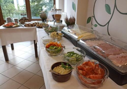 a buffet with many bowls of food on a table at Apartamenty Renesans in Krynica Zdrój