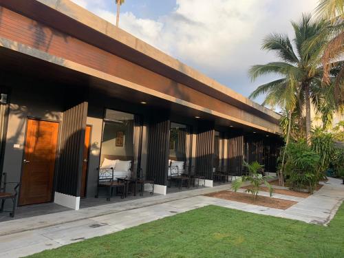 a resort with tables and chairs in a courtyard at The CHESS Samui in Chaweng
